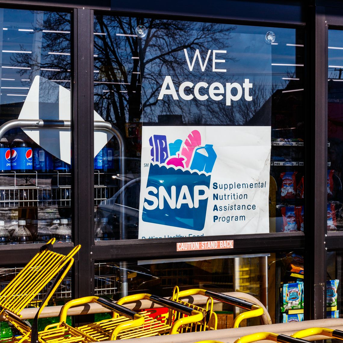 Convenient store displays We Accept SNAP Here sign on door