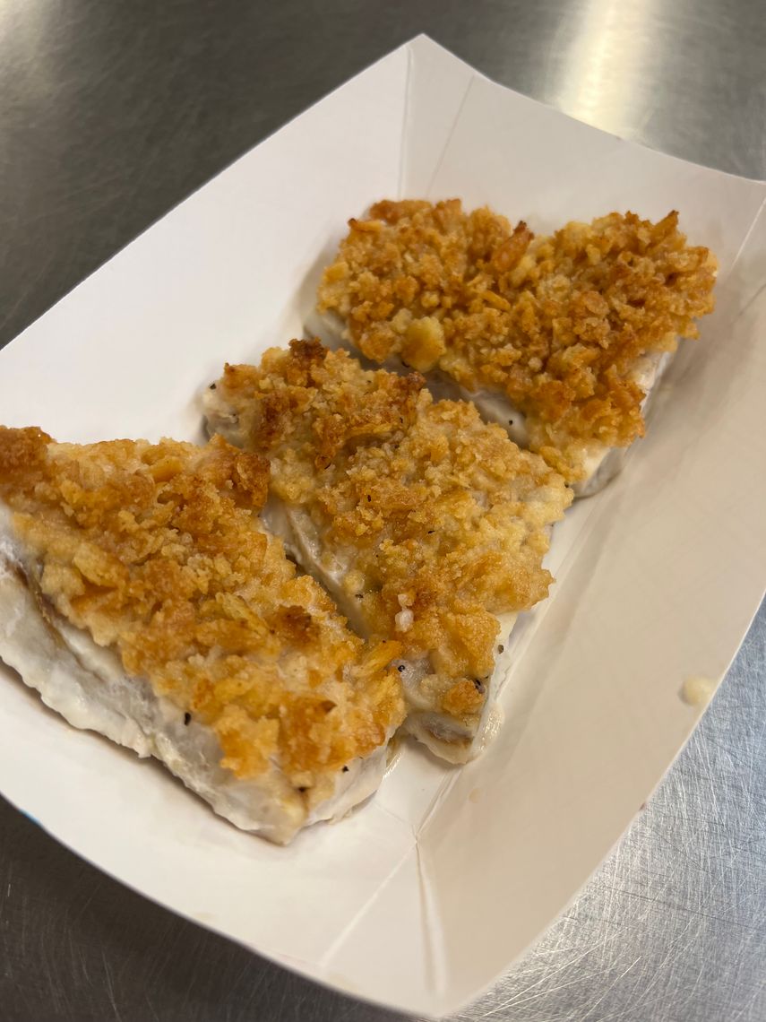 A few pieces of lemony and lightly fried fish in a small container.