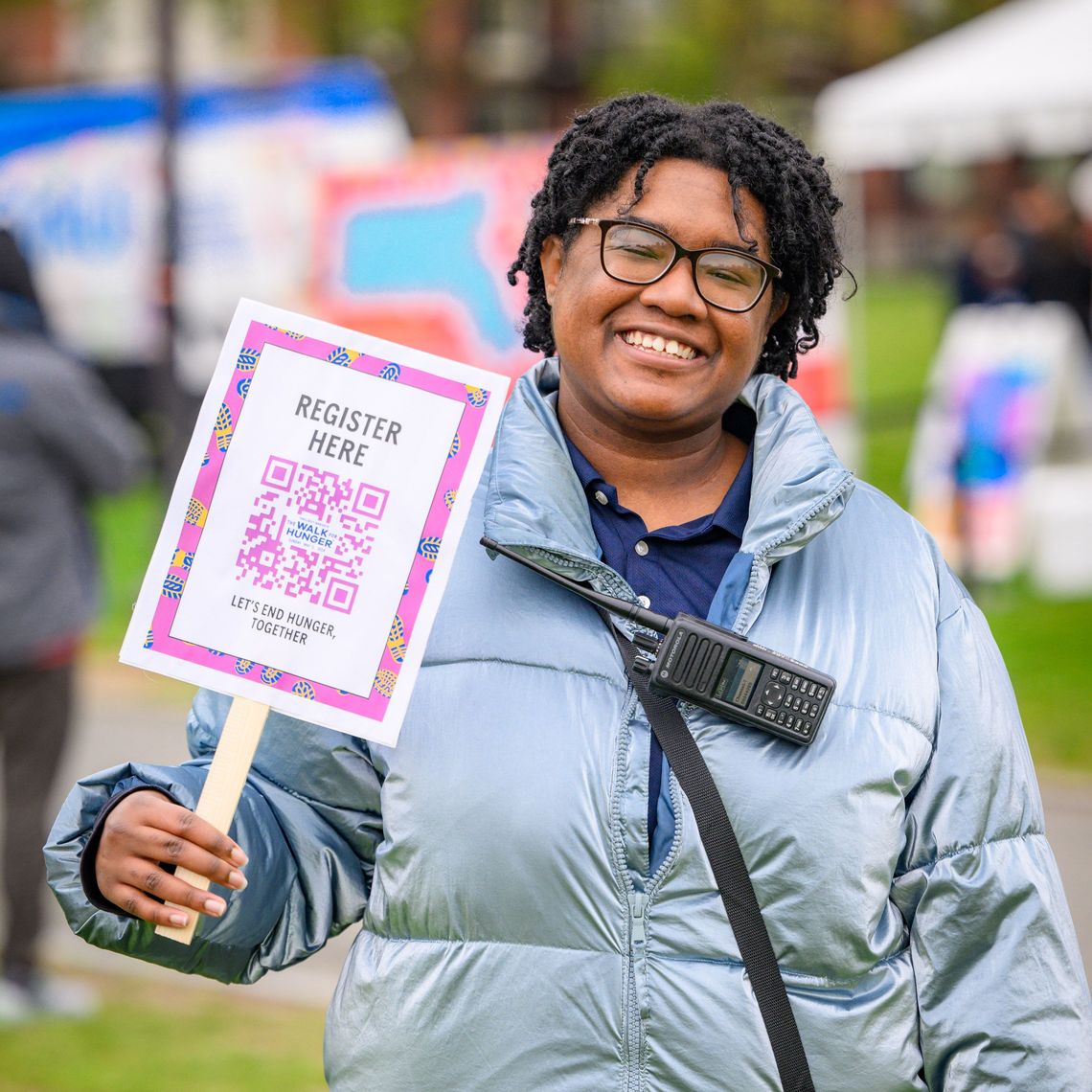 Walk volunteer smiles holding checkin sign