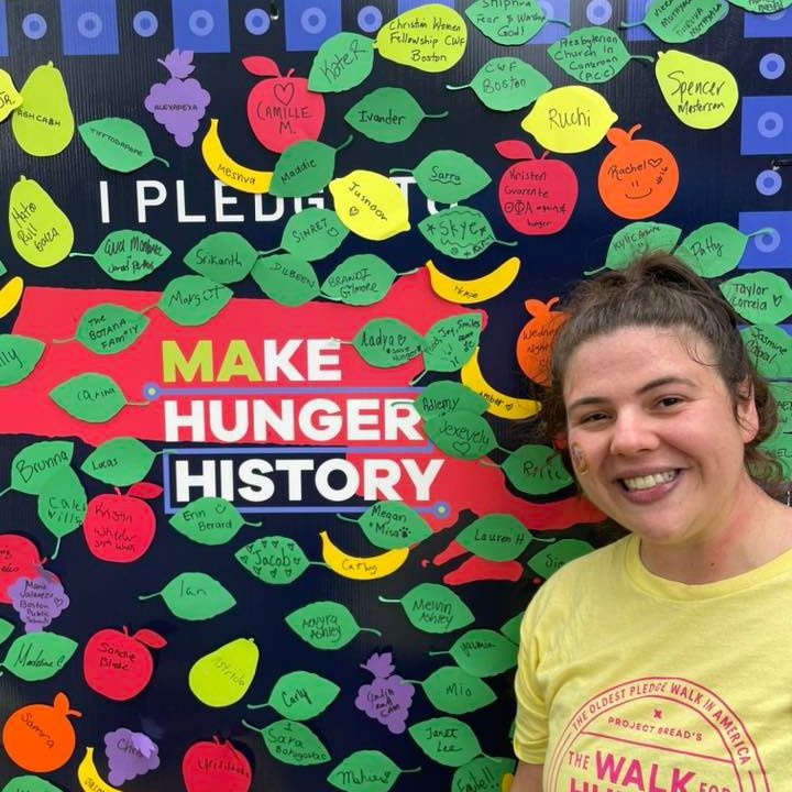 Women stands in from of the "i pledge to make hunger history" board