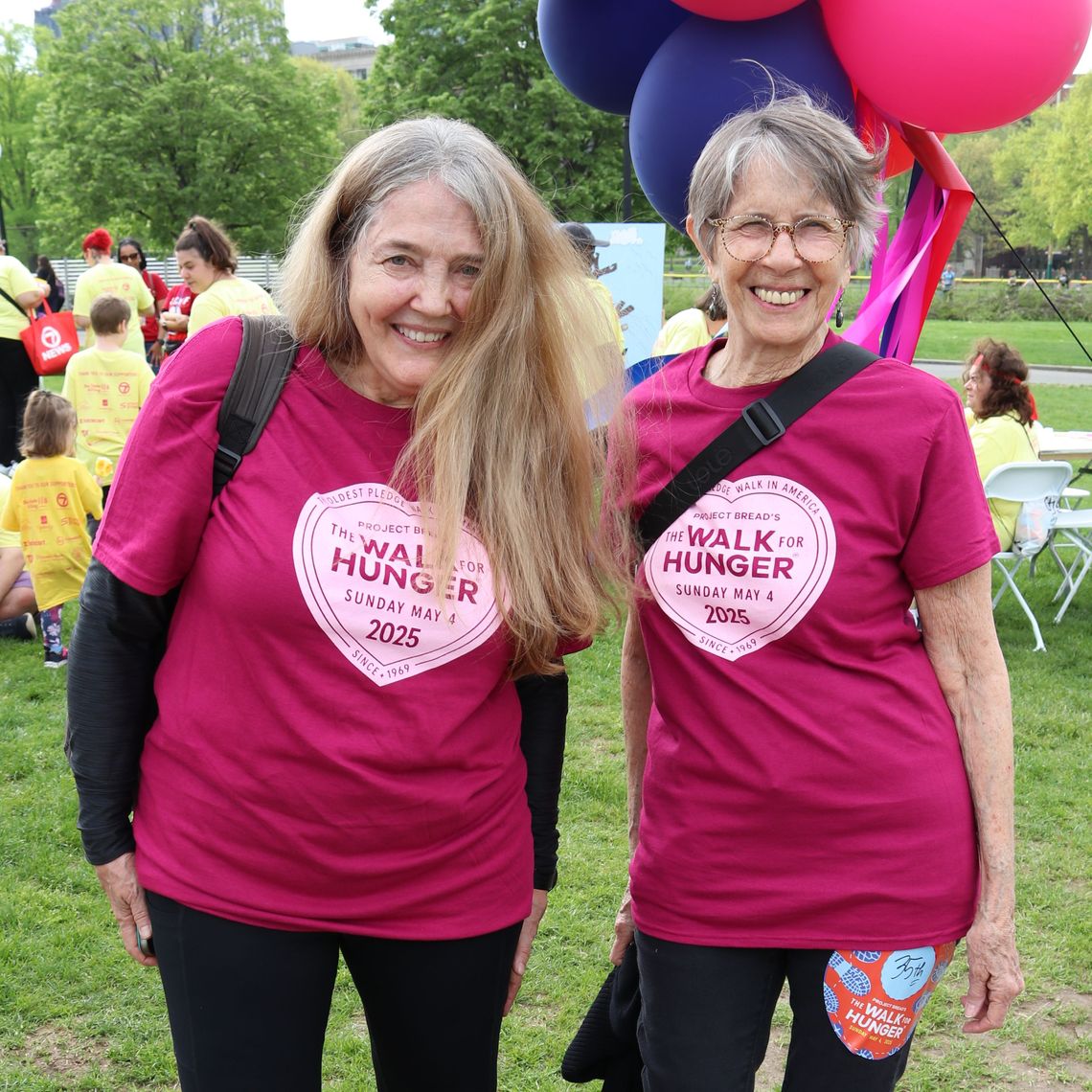 Two people stand under the balloon arch at The Walk for Hunger