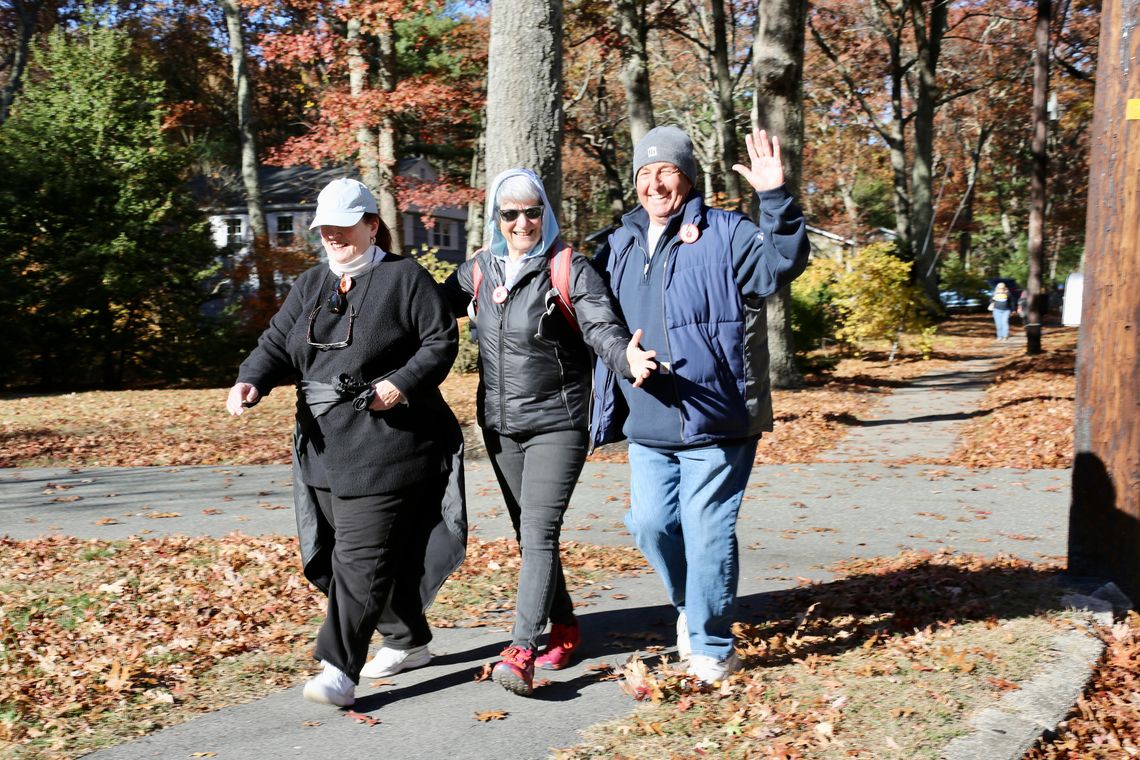 three smiling adults walking together